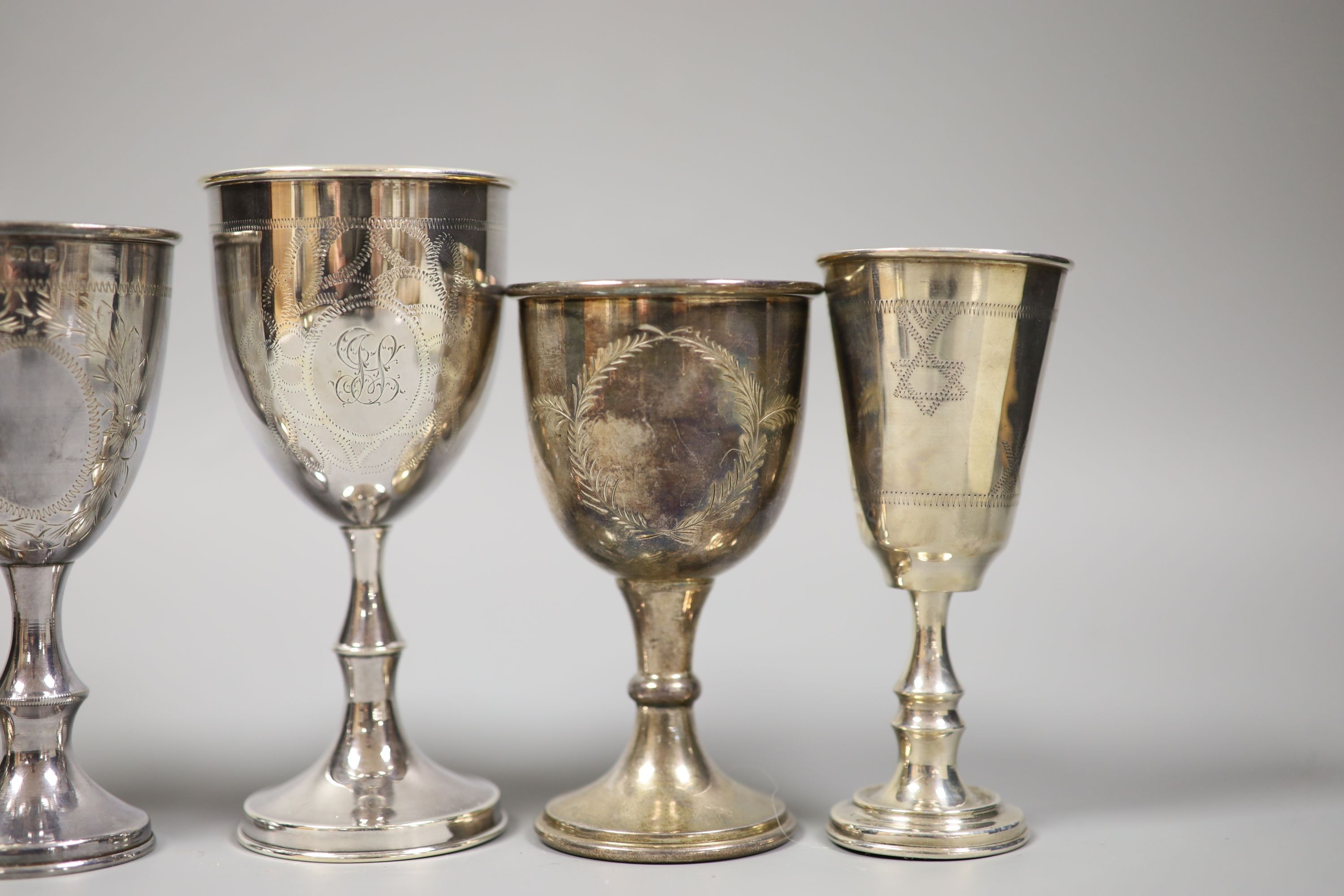 A silver kiddush cup, four other silver goblets and a late Victorian silver two handled dish, 13oz.